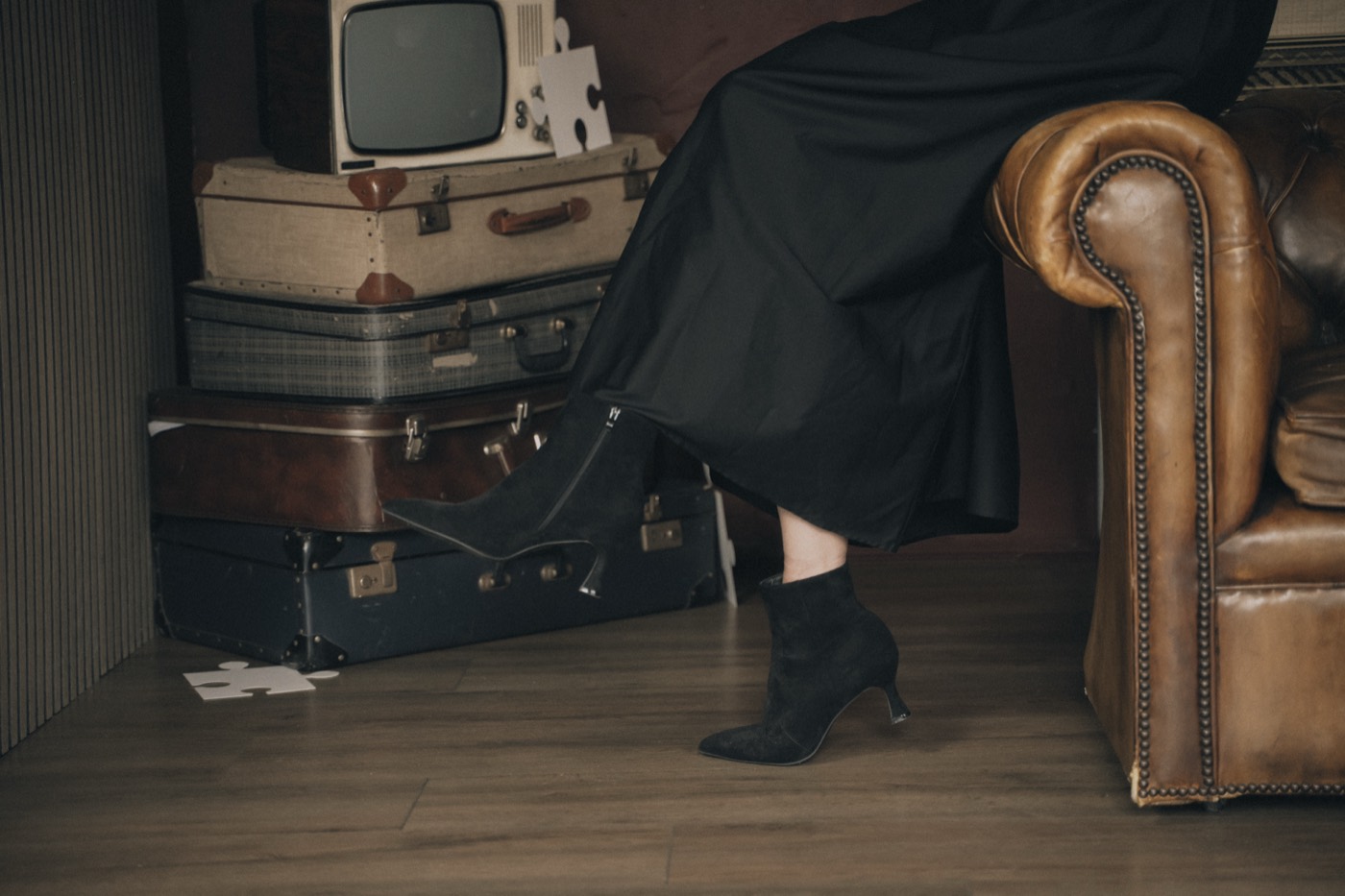 Detail van een vintage leren fauteuil en zwarte rok