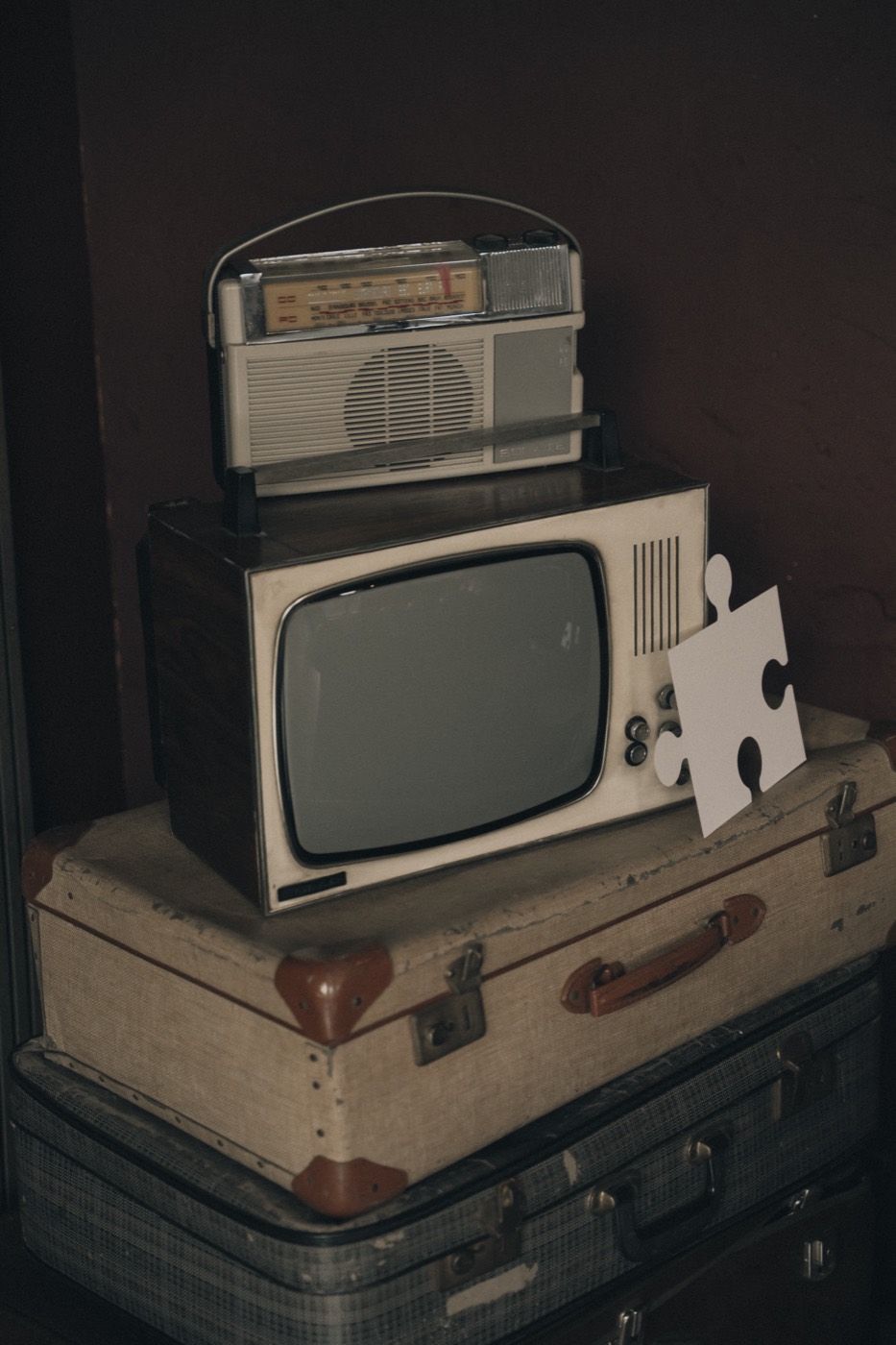 Oude televisie en radio op een stapel vintage koffers