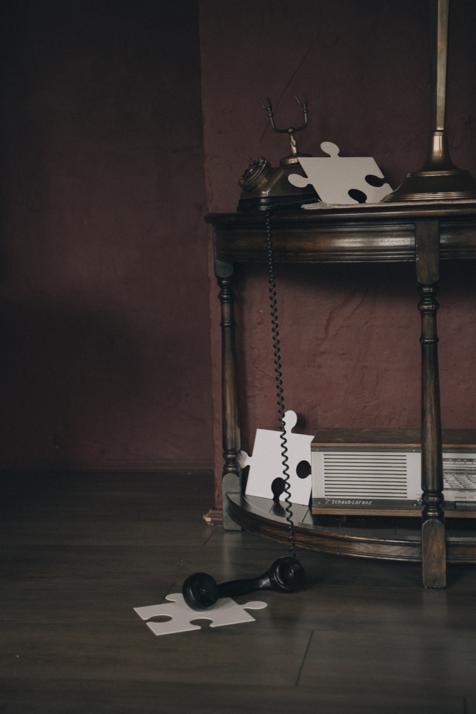 Vintage telefoon naast een puzzelstuk op de vloer